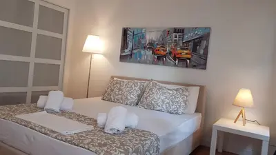 a bedroom with a bed with a painting on the wall at Ionian Apartment- Athens Center, 6 BD, 2.5 BATH in Athens
