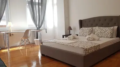 a bedroom with a bed and a chair in it at Ionian Apartment- Athens Center, 6 BD, 2.5 BATH in Athens