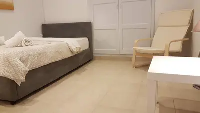 a bedroom with a bed and a chair at Ionian Apartment- Athens Center, 6 BD, 2.5 BATH in Athens