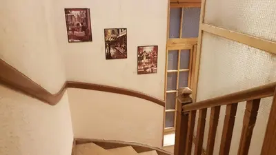 a hallway with a spiral staircase with pictures on the wall at Ionian Apartment- Athens Center, 6 BD, 2.5 BATH in Athens