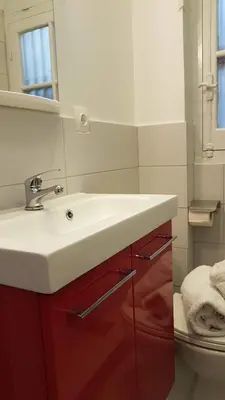 a bathroom with a white sink and a toilet at Ionian Apartment- Athens Center, 6 BD, 2.5 BATH in Athens