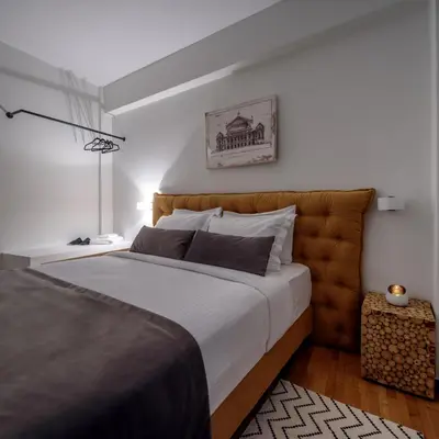 a bedroom with a large bed with a brown headboard at Acropolis Grand Apartment in Athens