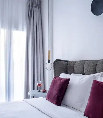 a bedroom with a white bed with purple pillows at Acropolis Grand Apartment in Athens