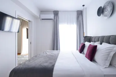 a bedroom with a large bed with red pillows at Acropolis Grand Apartment in Athens