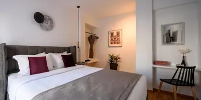 a bedroom with a large bed with red and white pillows at Acropolis Grand Apartment in Athens