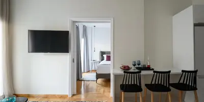 a room with a bed and a table with chairs at Acropolis Grand Apartment in Athens