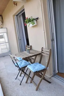 a wooden table and chairs in a room with a window at Sunny Apartment with view in Athens