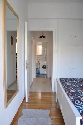 a bedroom with a bed and a mirror and a hallway at Sunny Apartment with view in Athens