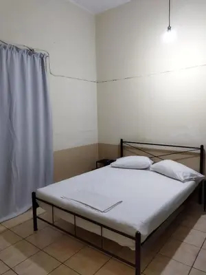 a bed with white sheets and pillows in a room at SAN REMO HOSTEL in Athens