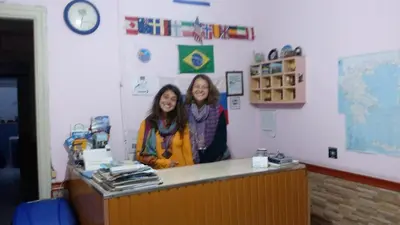 two girls standing behind a counter in a classroom at SAN REMO HOSTEL in Athens