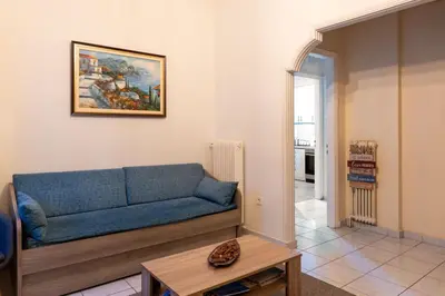 a living room with a blue couch and a table at Apartment @Katehaki Metro in Athens