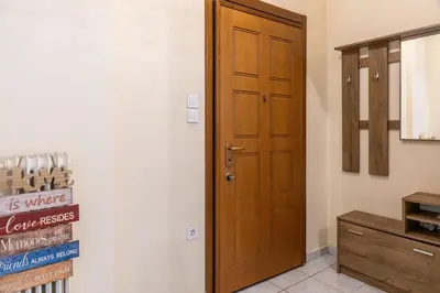 a room with a wooden door and a cabinet at Apartment @Katehaki Metro in Athens