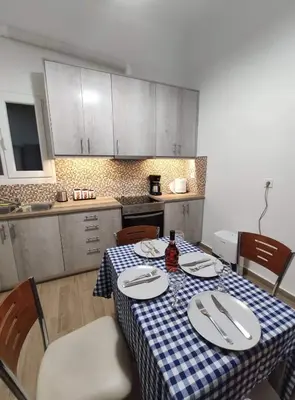 a kitchen with a table with a blue and white checkered table cloth at Apartment @Katehaki Metro in Athens