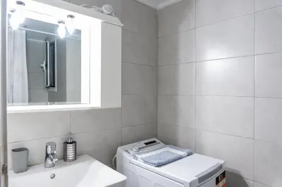 a bathroom with a sink and a washing machine at Apartment @Katehaki Metro in Athens