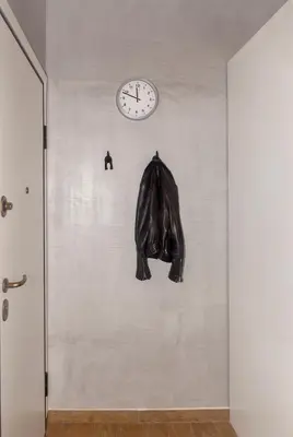 a clock on a wall with a jacket hanging on it at Stylish Loft In Athens VIPGreece in Athens