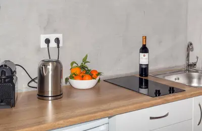a bottle of wine and a bowl of oranges on a kitchen counter at Stylish Loft In Athens VIPGreece in Athens