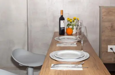 a wooden table with plates and a bottle of wine at Stylish Loft In Athens VIPGreece in Athens