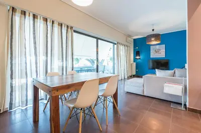 a dining room with a table and chairs and a bedroom at Glyfada Glass-Walled Designed Apt 1Gbps in Athens