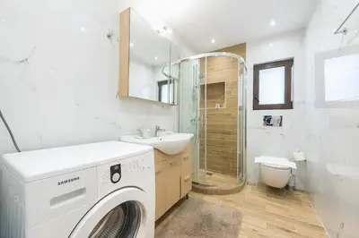 a bathroom with a washing machine and a sink at Glyfada Glass-Walled Designed Apt 1Gbps in Athens