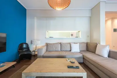 a living room with a couch and a table at Glyfada Glass-Walled Designed Apt 1Gbps in Athens