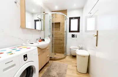 a bathroom with a washing machine and a sink at Glyfada Glass-Walled Designed Apt 1Gbps in Athens