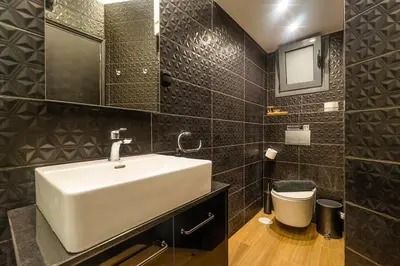 a bathroom with a white sink and a mirror at Super Stylish Apartments in the Heart of Athens! in Athens