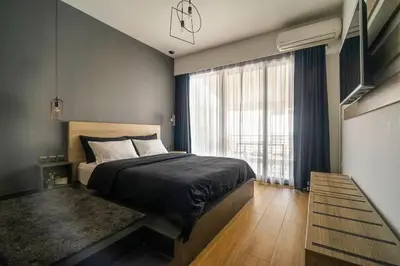 a bedroom with a bed and a large window at Super Stylish Apartments in the Heart of Athens! in Athens