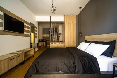 a bedroom with a large bed and a television at Super Stylish Apartments in the Heart of Athens! in Athens