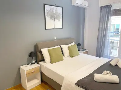 a bedroom with a large bed and a window at Check Point - Veikou in Athens