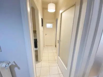 a hallway with a door leading into a bathroom with a tile floor at Check Point - Veikou in Athens