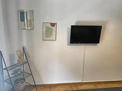 a flat screen tv on a white wall at Check Point - Veikou in Athens