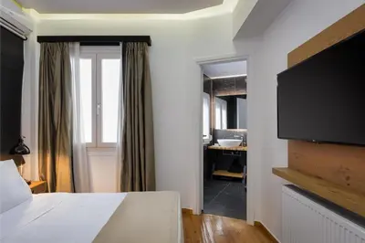 a bedroom with a bed and a flat screen tv at Acropolis Unique Residence in Athens