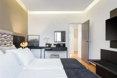 a bedroom with a white bed and a desk at Acropolis Unique Residence in Athens