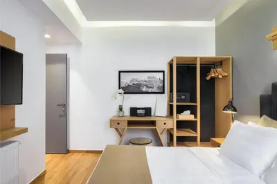 a bedroom with a bed and a desk with a computer at Acropolis Unique Residence in Athens