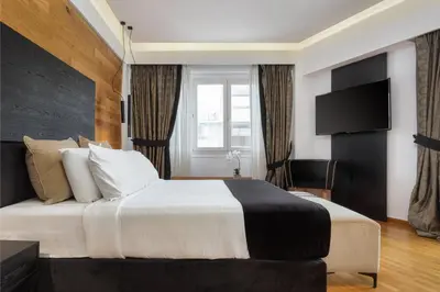 a hotel room with a large bed and a television at Acropolis Unique Residence in Athens