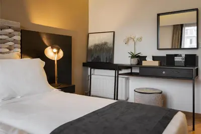 a bedroom with a bed and a desk with a mirror at Acropolis Unique Residence in Athens