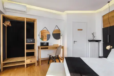 a bedroom with a bed and a desk and mirror at Acropolis Unique Residence in Athens