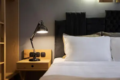 a lamp on a night stand next to a bed at Acropolis Unique Residence in Athens
