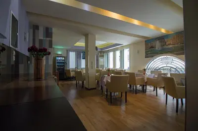 a dining room with tables and chairs in a building at Cosmopolit in Athens