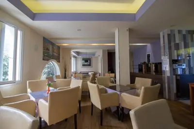 a dining room with tables and chairs and a window at Cosmopolit in Athens