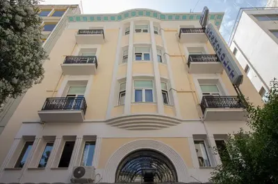 a tall yellow building with balconies on it at Cosmopolit in Athens