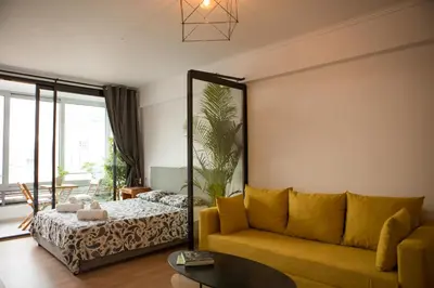 a living room with a yellow couch and a bed at Mosaics aprtm in Parliament square with Acropolis View 14 in Athens