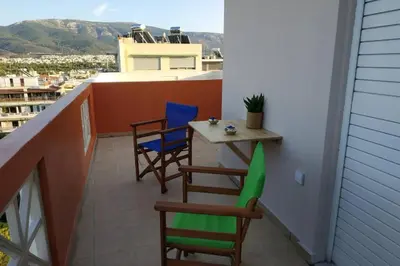 a balcony with chairs and a table on a building at Psychiko's View in Athens