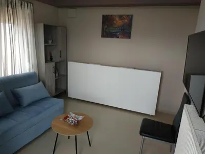 a living room with a blue couch and a table at Psychiko's View in Athens