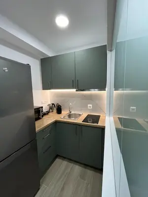 a kitchen with green cabinets and a sink at Academys Modern Apartments by Athens Urban Retreat in Athens