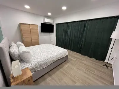 a bedroom with a bed and a green curtain at Academys Modern Apartments by Athens Urban Retreat in Athens