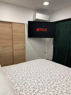 a bedroom with a bed and a netflix sign at Academys Modern Apartments by Athens Urban Retreat in Athens