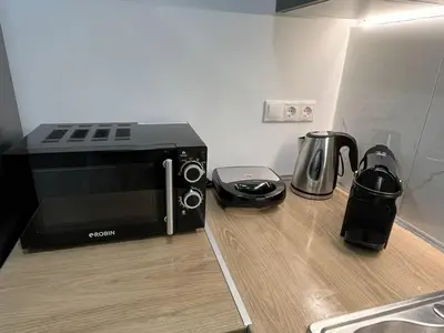 a microwave sitting on a counter next to a coffee maker at Academys Modern Apartments by Athens Urban Retreat in Athens
