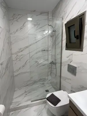 a bathroom with a shower with a toilet and a television at Academys Modern Apartments by Athens Urban Retreat in Athens