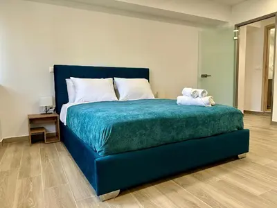 a bedroom with a blue bed with a teddy bear on it at Academys Modern Apartments by Athens Urban Retreat in Athens